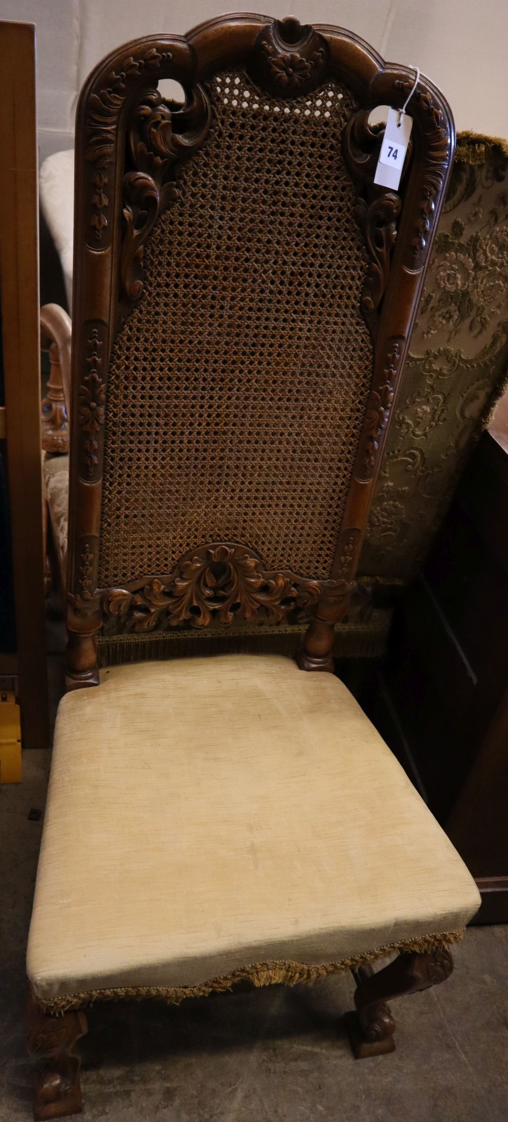 A 19th century Flemish style carved walnut armchair, upholstered in brocade and a Georgian style caned walnut dining chair